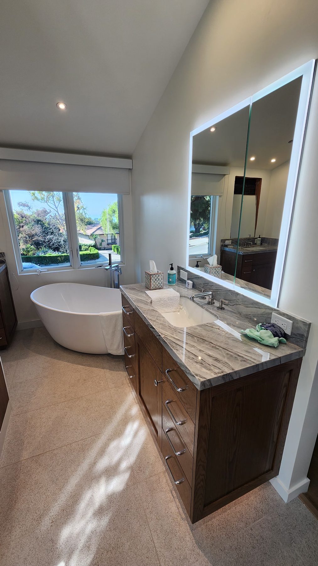 Spa bathroom remodel with freestanding tub and walnut vanity
