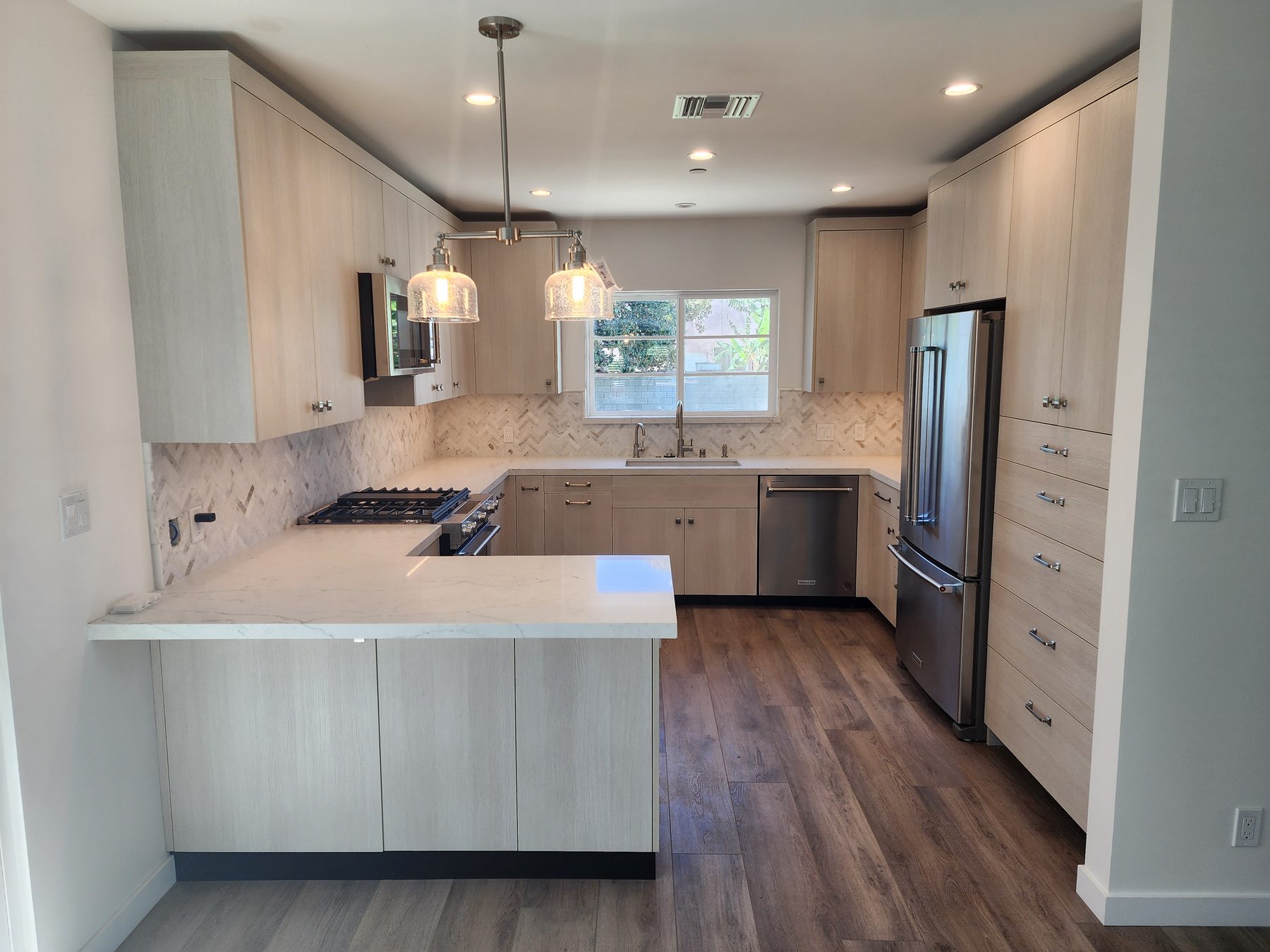 Light wood kitchen with herringbone backsplash in Mar Vista